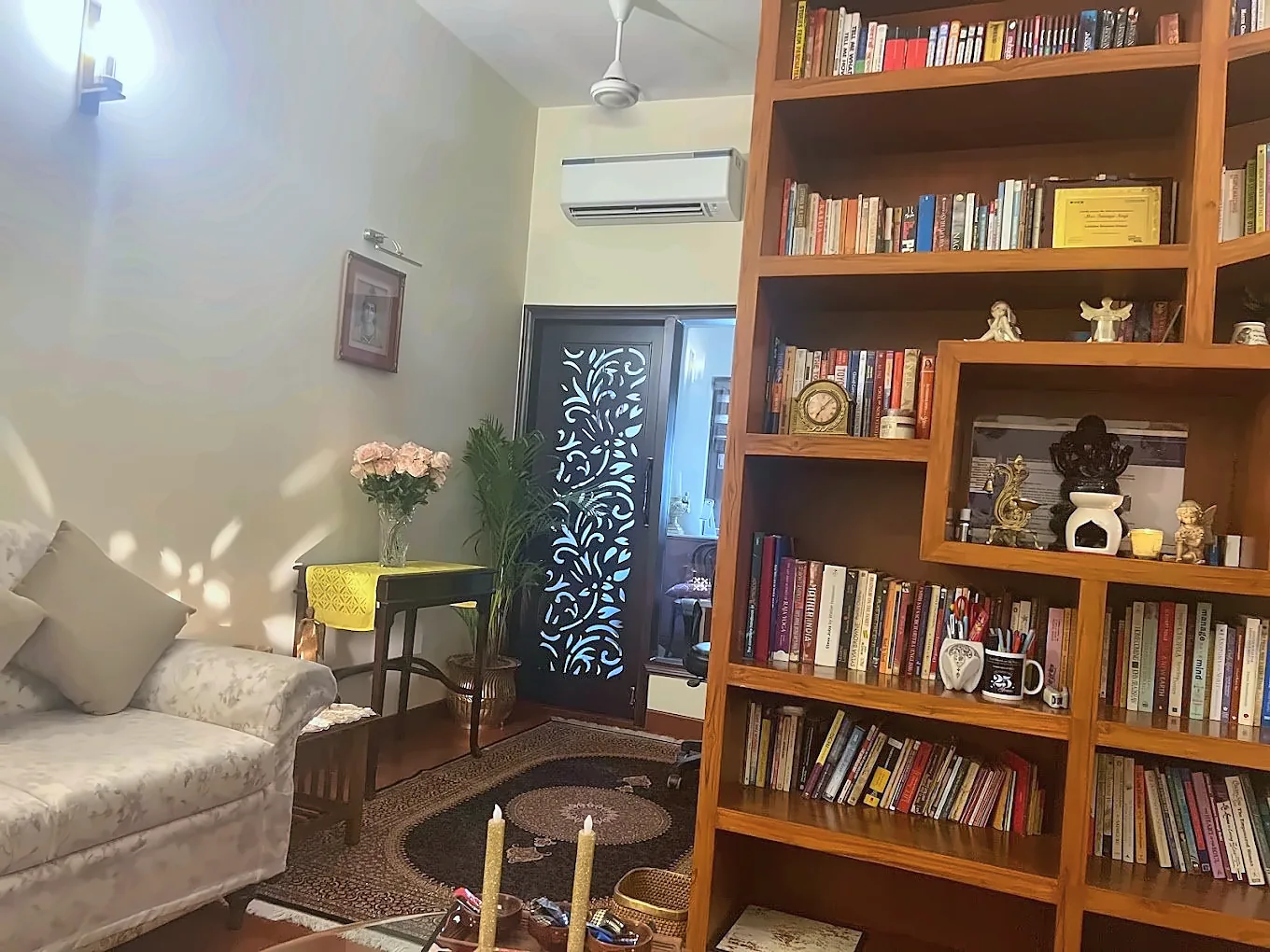 The counselling room at Holistic Healing Centre: a cream sofa, warm lamps and shelves of books